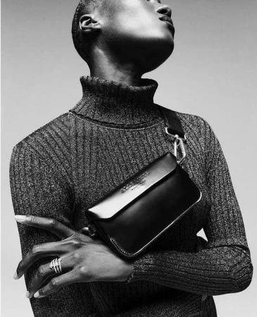 Black and white portrait of a black woman wearing a turtleneck sweater and a black crossbody bag by Sebastien Giraud