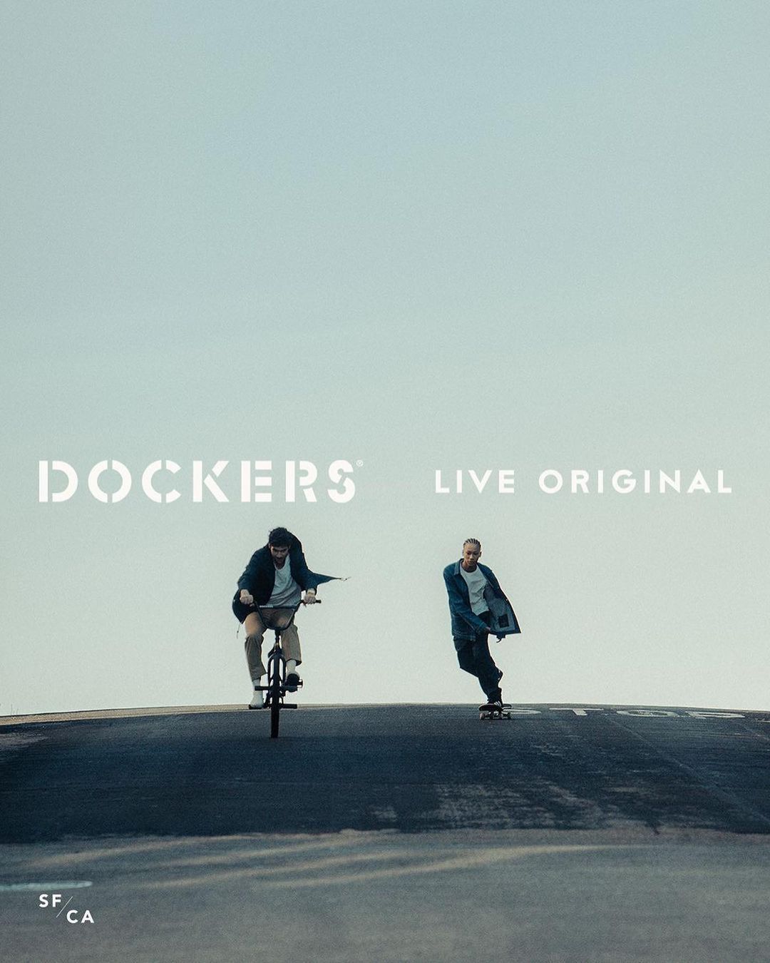 Two people on a street, one rides a BMX bike, and the other rides a skateboard, with the Dockers logo above them.