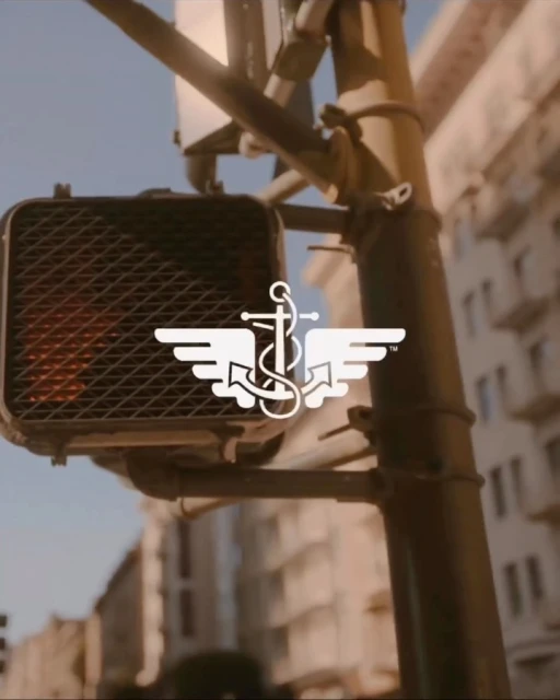 A traffic light with a Dockers logo overlayed, positioned in front of a blurred city building background, evoking an urban feel.