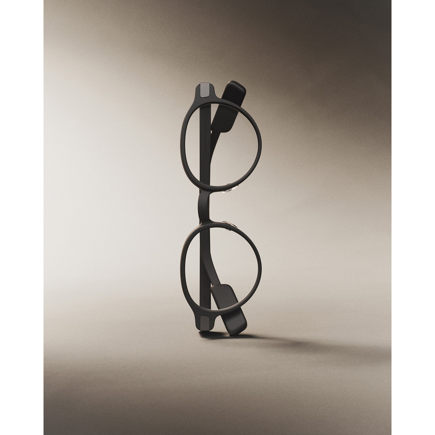 Studio shot of gray eyeglasses, displayed upright. The lighting highlights the sleek design and matte texture against a gradient background.