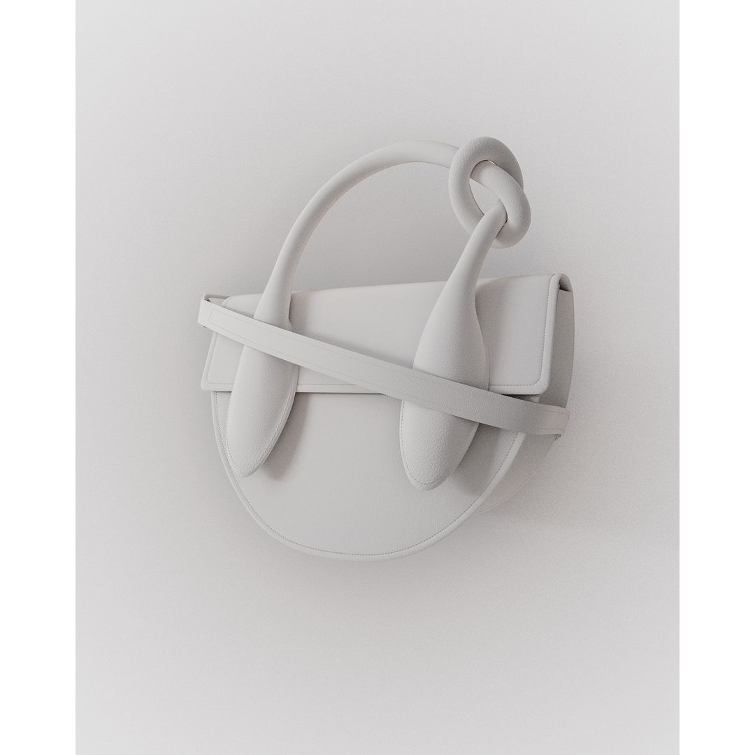 Minimalist fashion shot of a white handbag with a unique knotted handle, against a bright white backdrop in a photo studio setting.