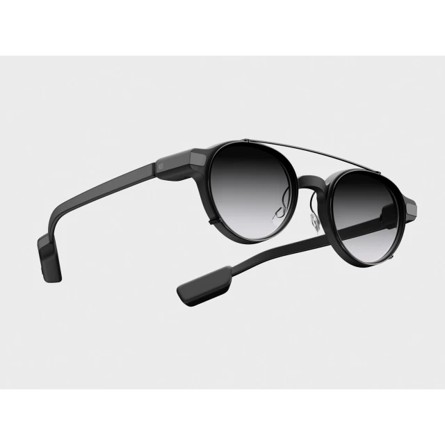 Black sunglasses with round gradient lenses on a white background, showcasing modern eyewear design and optical technology.