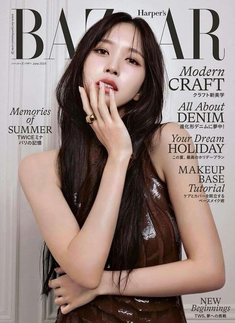 Magazine cover featuring a woman with long dark hair wearing a sparkly dress, posing with her hand near her face in a studio setting.