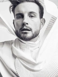 Portrait of a man in a white pleated garment photographed by Seiji Fujimori in New York.