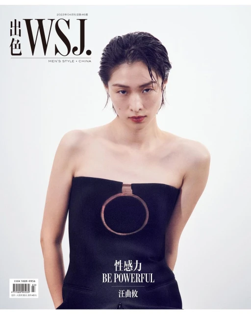 Magazine cover featuring a woman in a black strapless top with a circular detail against a bright white background in a studio setting.