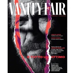 Close-up monochrome portrait of a bearded man featured on a Vanity Fair magazine cover with a torn paper effect.