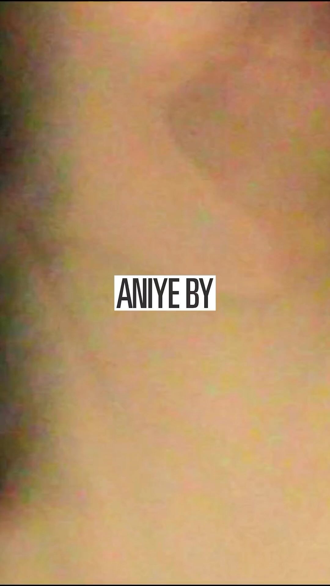 Close-up of a blurred background with the white text overlay 'ANIYE BY' centered in the frame. Abstract image with limited visibility.
