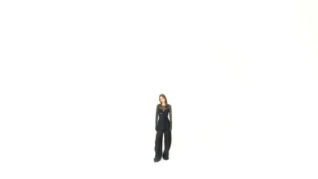 Model wearing a black outfit standing small against a vast bright white background shot by Sergei Antonov