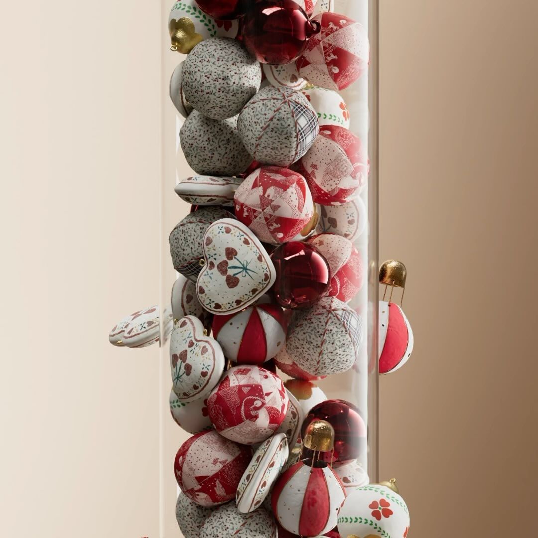 Close-up of decorative glass cylinder filled with red and white patterned ornamental spheres against a neutral background.