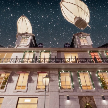 Whimsical building facade at night with lit windows, holiday wreaths, and two hot air balloon-shaped lanterns floating above.