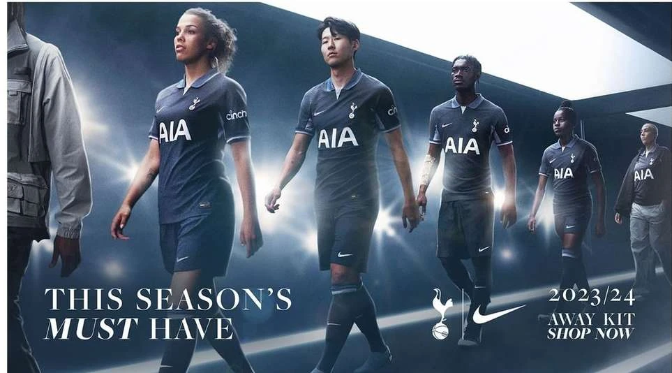 A group of male and female fashion models in soccer uniforms walk toward the viewer, showcasing the 2023/24 away kit.