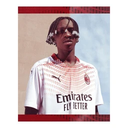 Portrait of young Black man with braided hair wearing a white patterned football jersey by Shamil Tanna
