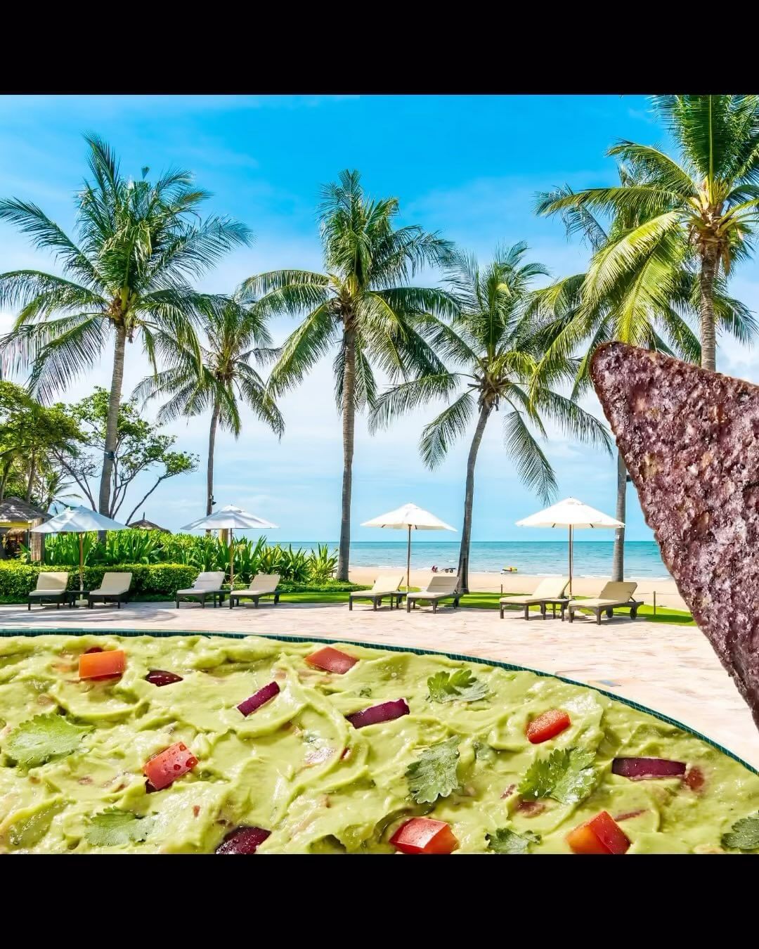 An inviting food still-life captures a bowl of fresh guacamole with a tortilla chip, set against a beach scene with palm trees.