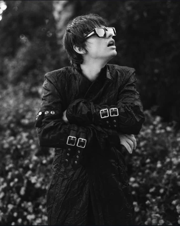 Monochrome portrait of a person wearing sunglasses and a buckled jacket outdoors in New York by Shane Mccauley