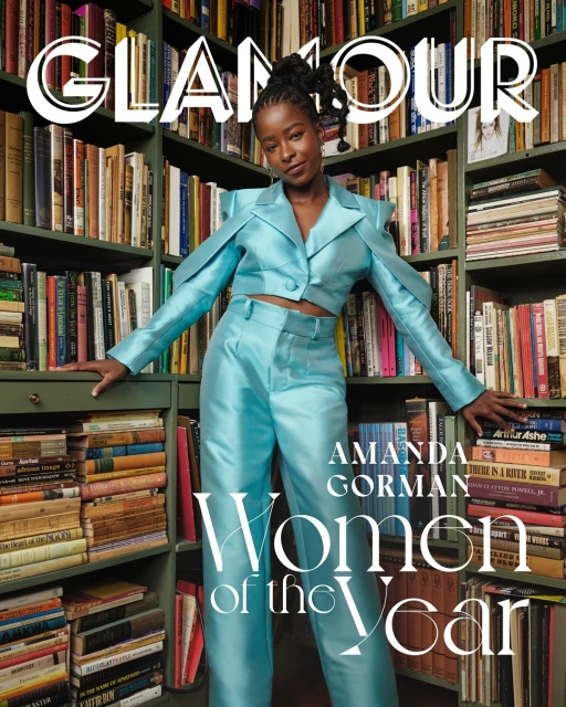 Glamour magazine cover featuring Amanda Gorman in a teal suit, posing in front of a bookshelf filled with colorful books.