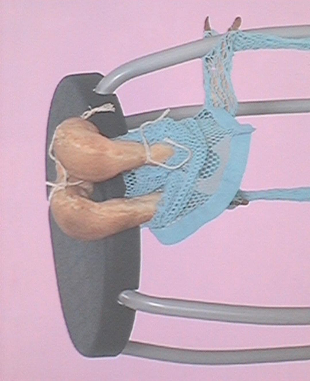 Abstract still life featuring a gray clothing rack, light blue net, and tan objects against a pink background, showcasing textures and colors.