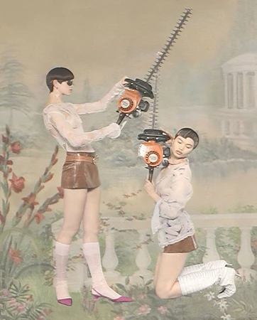 Two women in sheer tops and mini skirts hold hedge trimmers against a painted backdrop. Fashion editorial with garden machinery.