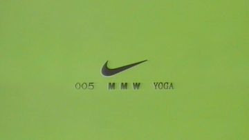 Minimalist image of a green surface with the Nike swoosh and the text '005 MMW YOGA' in a simple, modern sans-serif font.