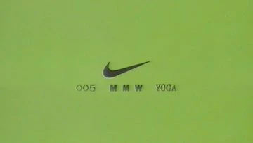 Minimalist image of a green surface with the Nike swoosh and the text '005 MMW YOGA' in a simple, modern sans-serif font.
