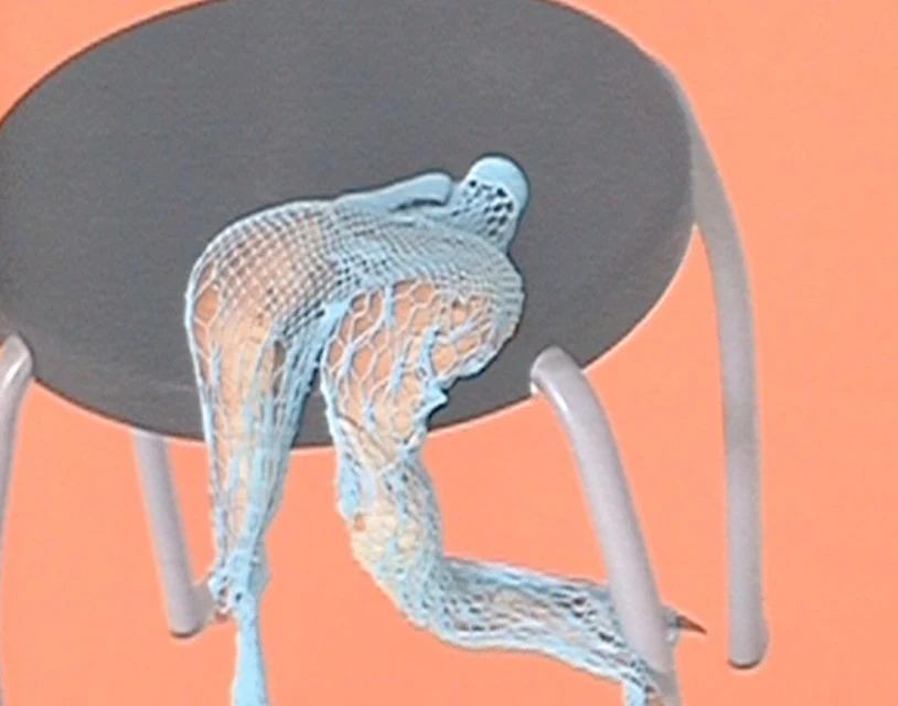Abstract studio shot of a gray stool with blue fishnet draped over the seat, set against a peach-colored backdrop.
