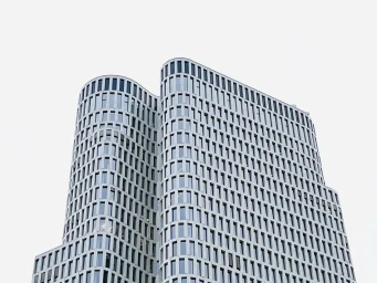 Low-angle shot of a modern curved architectural skyscraper with repeating grid windows against an overcast sky