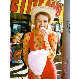 Woman wearing a cowboy hat and star print top holding pink cotton candy photographed by Shelby Duncan.
