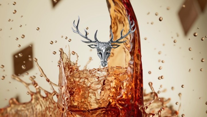 Bronze liquid and chocolate collide with a silver deer head in a warm-toned studio setting, captured with a shallow depth of field.