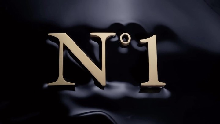 Elegant gold 'N°1' lettering on a glossy black background. Minimalist luxury aesthetic, product presentation, and cosmetic branding. 