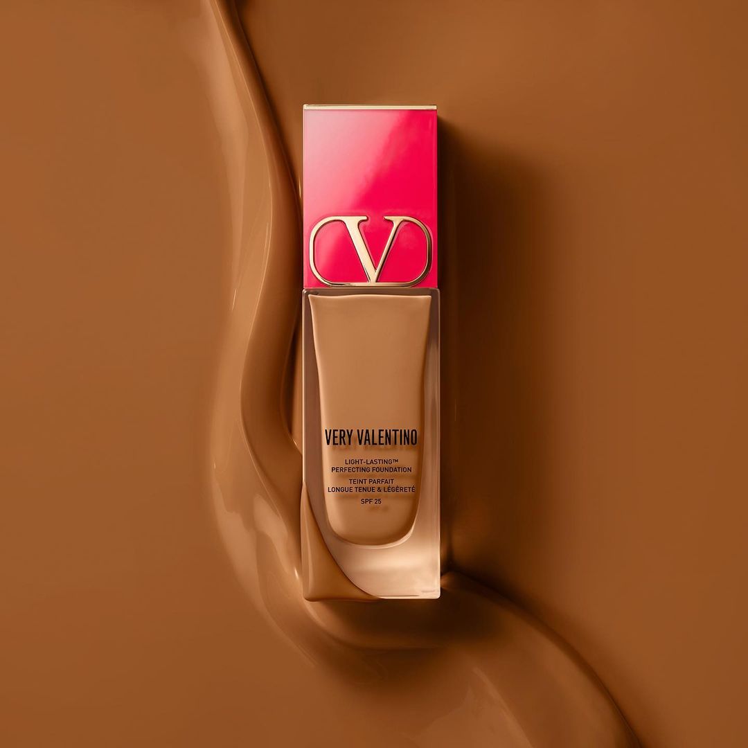 Valentino Very Valentino light-lasting perfecting foundation shown against a swirling brown background, beauty and makeup product.