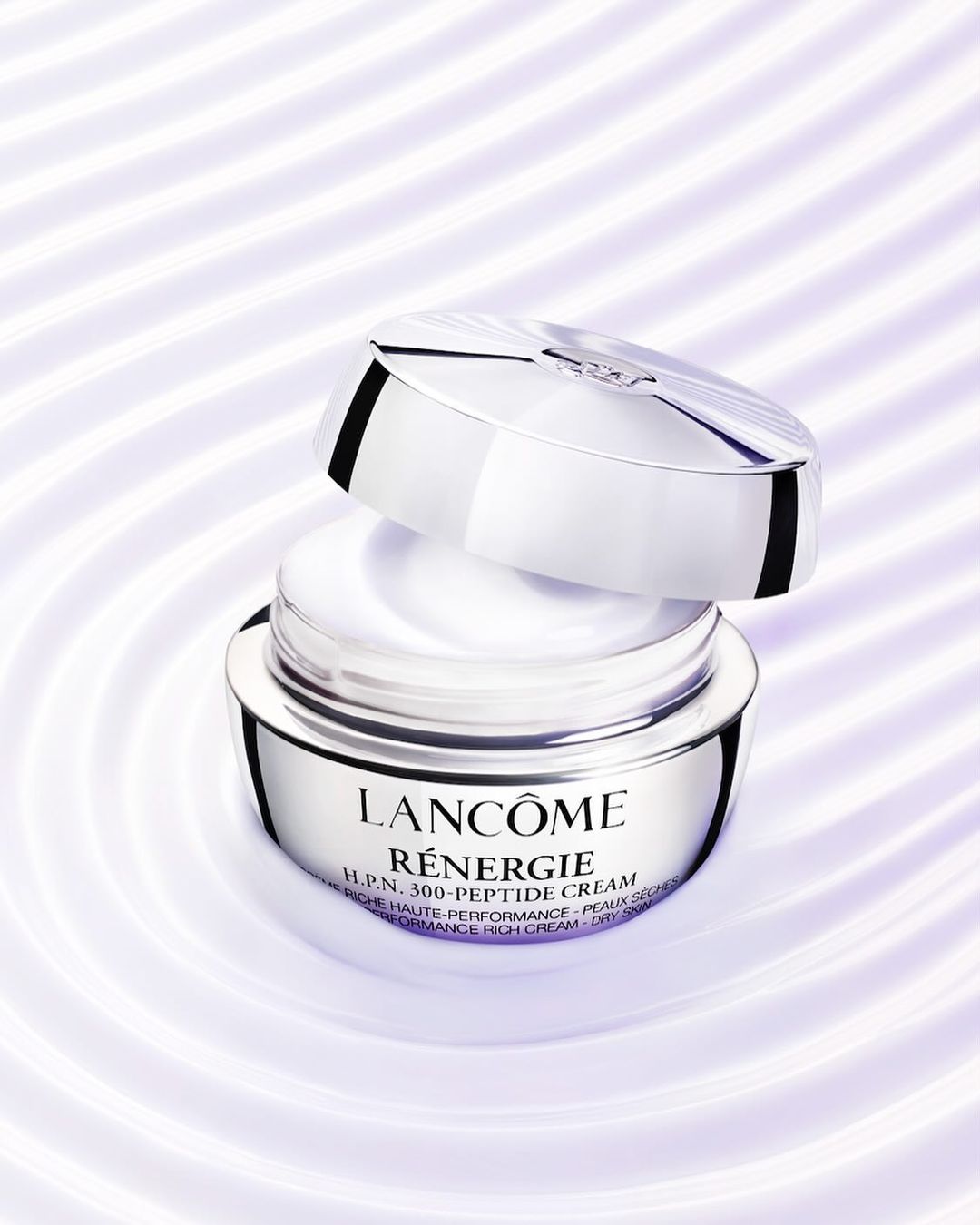 Lancôme Renergie H.P.N. 300-Peptide Cream jar and lid on a swirling off-white surface. The product's label features black text.