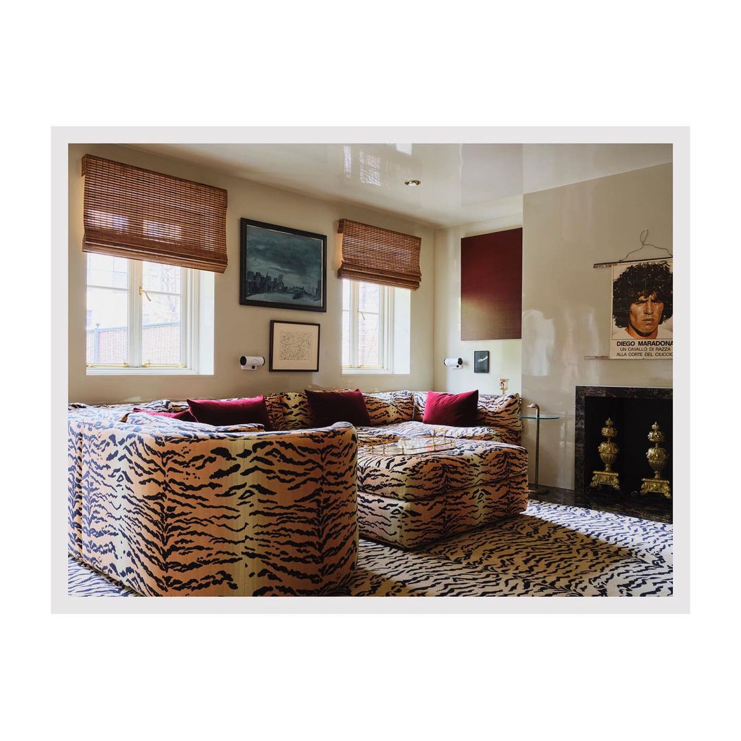 Interior of a living room featuring a large sectional sofa with a tiger print pattern, complemented by matching area rug and throw pillows.