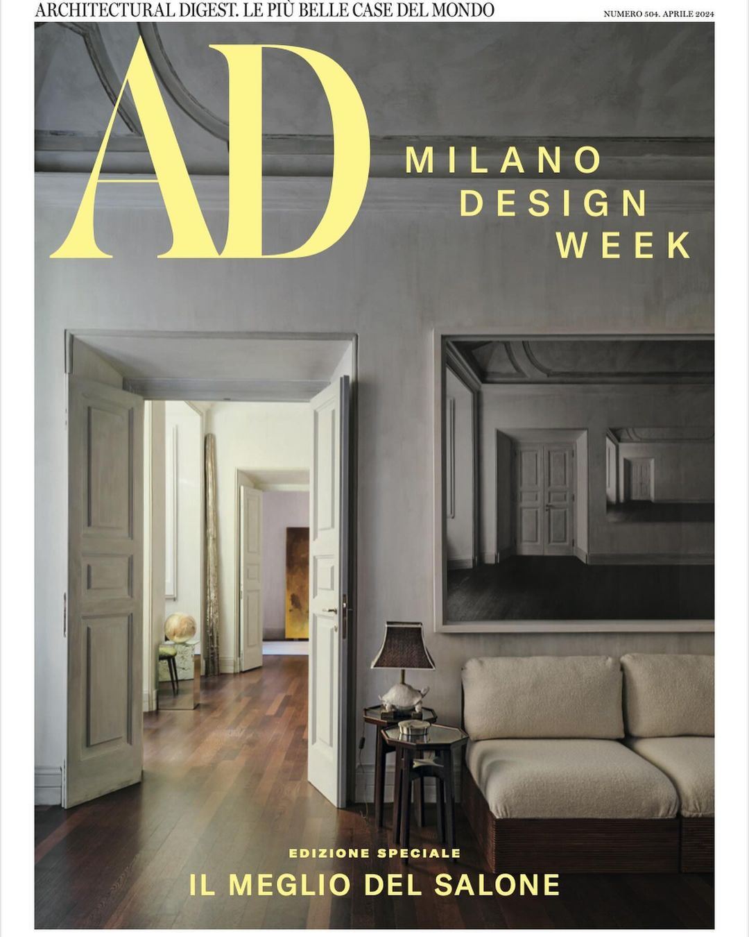 Architectural Digest cover featuring an interior hallway with open doorways and a glimpse of a room with a sofa, table, and lamp.