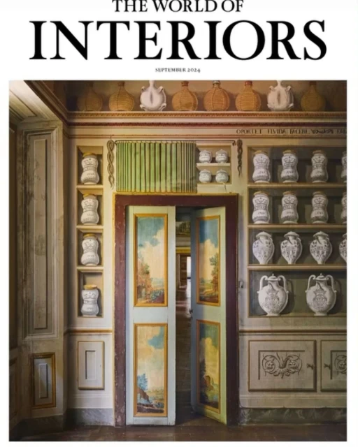 Interior shot featuring a magazine cover of 'The World of Interiors' September 2024, with antique cabinet and painted double doors.