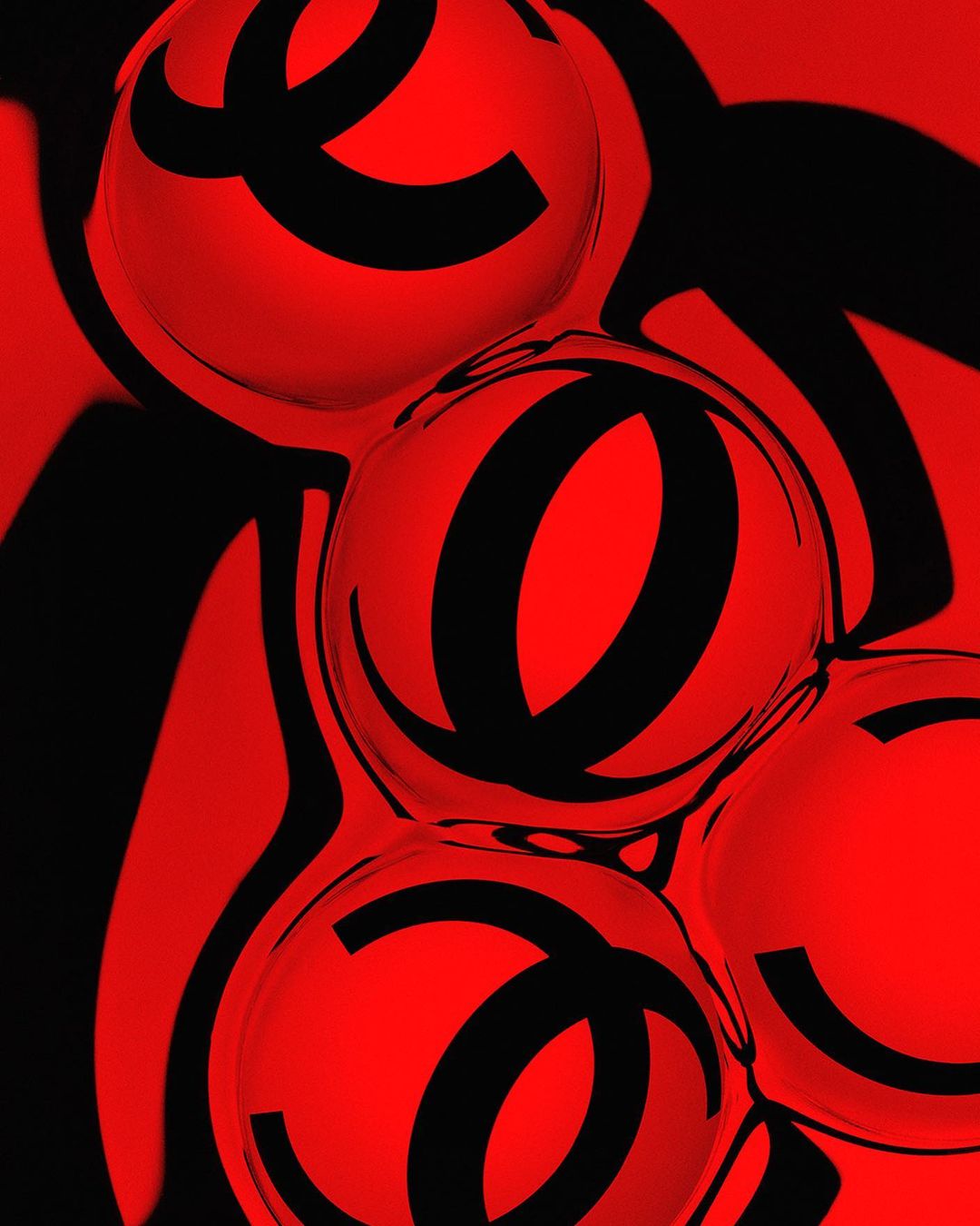 Abstract image featuring a black emblem reflected in multiple red spheres, creating a distorted and repetitive pattern on dark background.