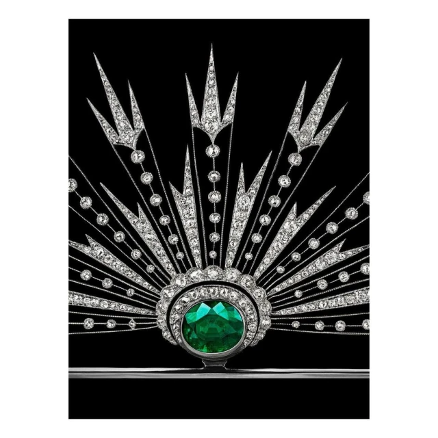 Emerald and diamond jewelry brooch featuring art deco design and a silver setting against a solid black background.