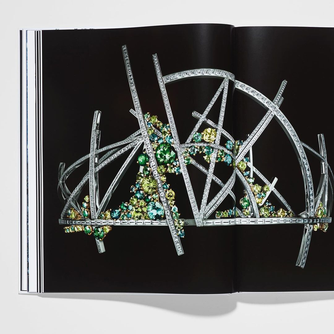 Intricate geometric tiara with sparkling accents, displayed on a book page against a dark backdrop, highlighting jewelry design.