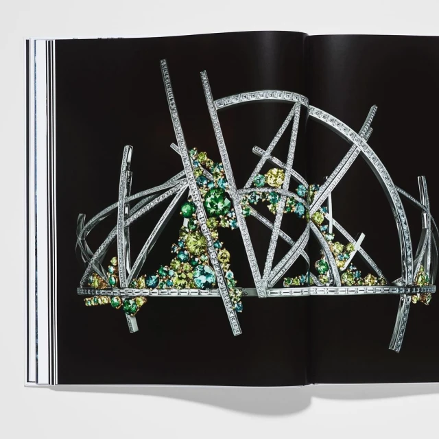 Intricate geometric tiara with sparkling accents, displayed on a book page against a dark backdrop, highlighting jewelry design.
