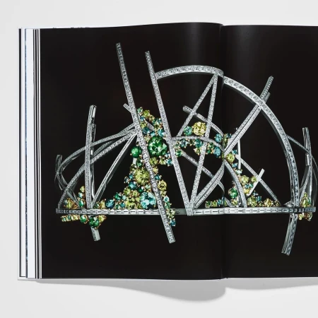 Intricate geometric tiara with sparkling accents, displayed on a book page against a dark backdrop, highlighting jewelry design.