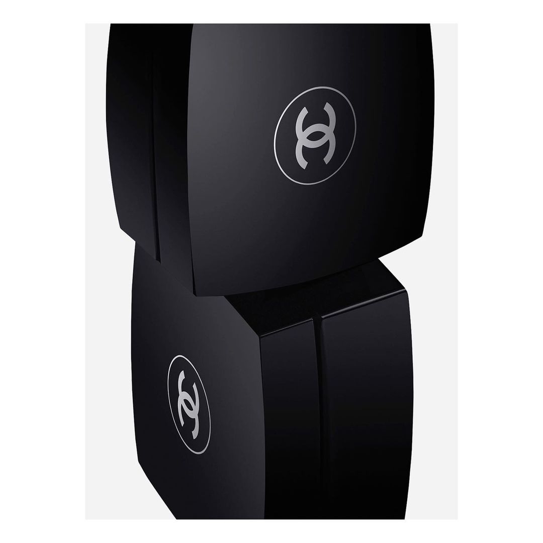 Two stacked black cosmetic boxes with silver logos on a plain white backdrop, minimalist presentation, beauty and luxury concept.