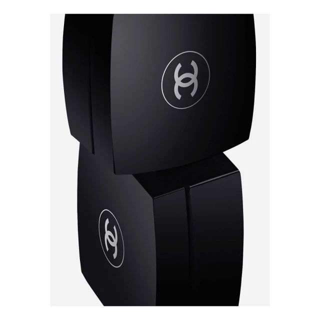 Two stacked black cosmetic boxes with silver logos on a plain white backdrop, minimalist presentation, beauty and luxury concept.