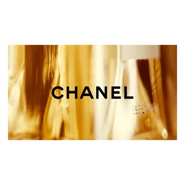 Close-up of the word "CHANEL" on a gold-toned surface. The text is in black and is centered on the horizontal rectangle.