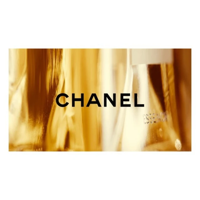 Close-up of the word "CHANEL" on a gold-toned surface. The text is in black and is centered on the horizontal rectangle.