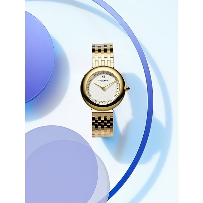 Elegant gold wristwatch with a white face displayed against a light backdrop with blue accents, ideal for fashion and product advertising.
