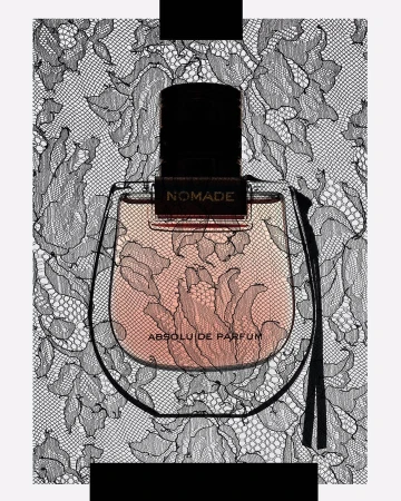 Close-up of Nomade Absolu de Parfum bottle with a black stopper, featuring intricate black floral lace patterns in the background.