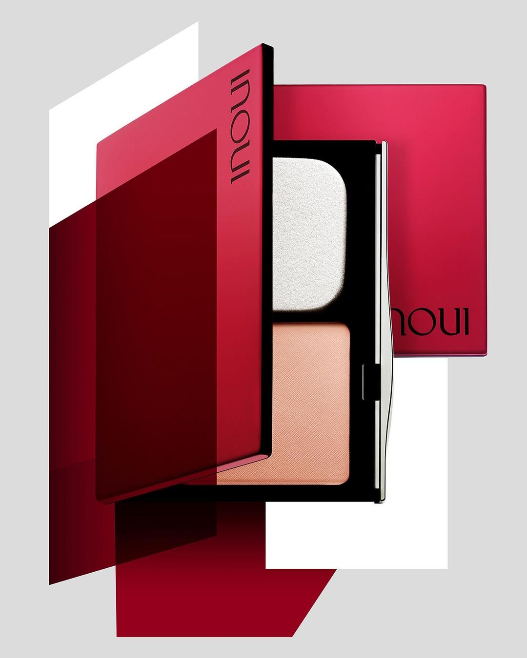 INOUI makeup compacts in red and black packaging, including powder and sponge, set against a gray background with geometric overlays.