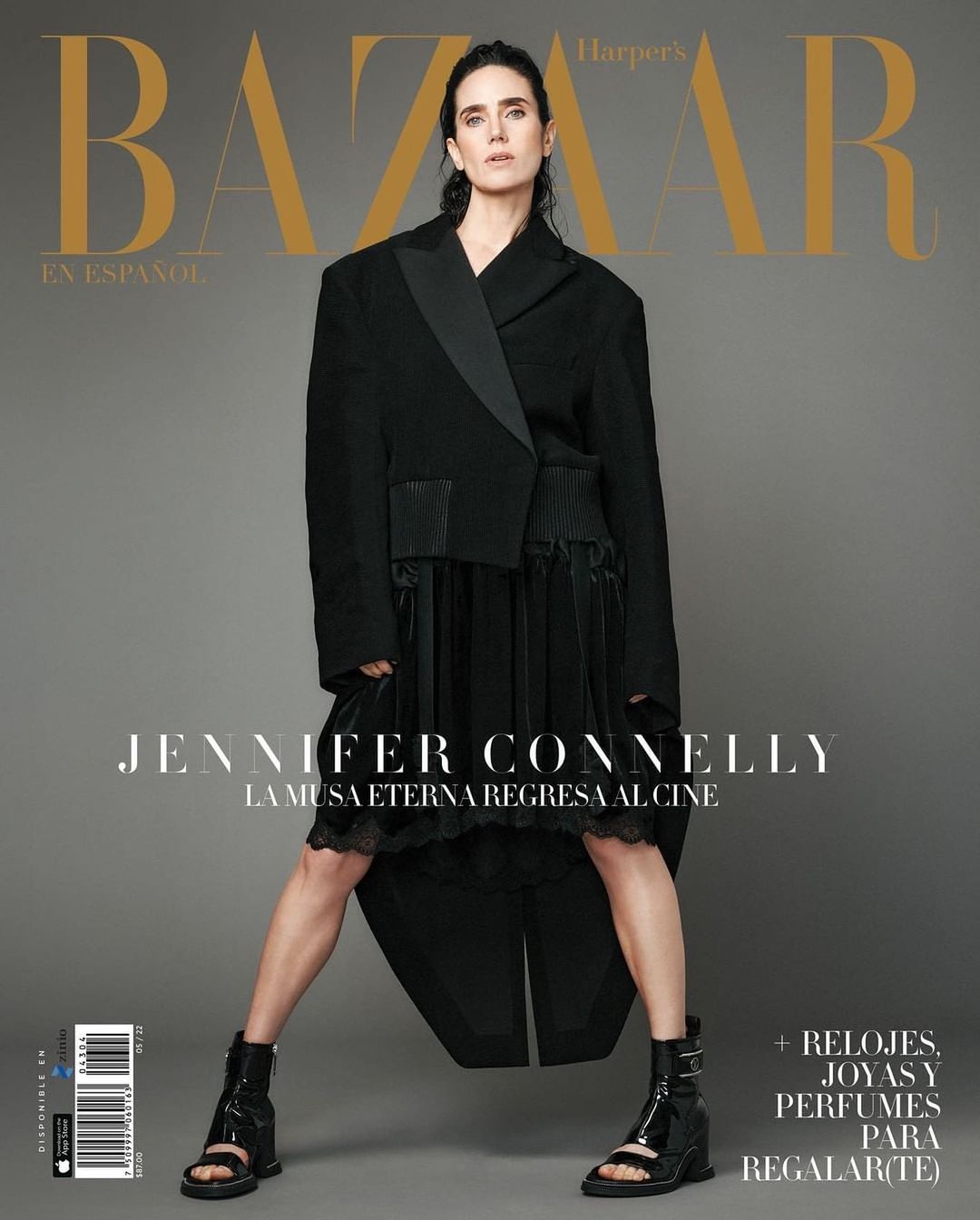 Jennifer Connelly poses in a black blazer-dress on a magazine cover. Full shot of an adult woman standing against gray backdrop.