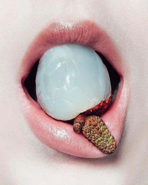 Close-up portrait of a person with a lychee in their mouth, showcasing the fruit's texture and the person's lips.