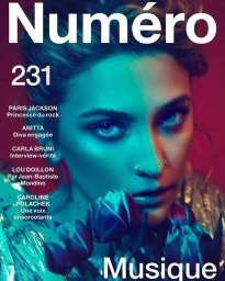 Close-up portrait of Paris Jackson holding flowers under dramatic blue and magenta lighting for a Numéro magazine cover.