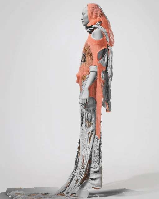 Grey mannequin wearing a flowing, grey and salmon-colored dress with an intricate design, side view on white background in studio.