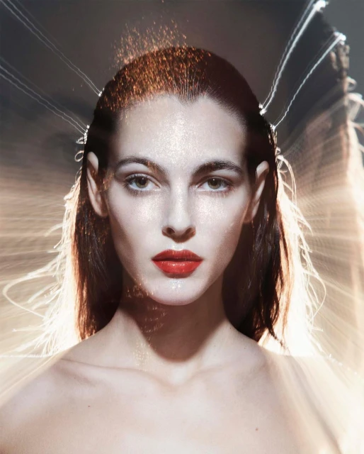 Close-up portrait of a female model with fair skin, red lipstick, and wet hair, illuminated by dynamic lighting and blurred background streaks.
